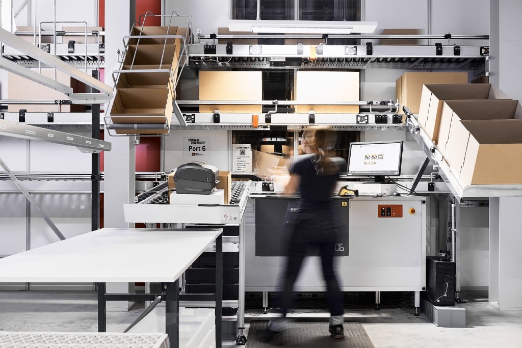 Warehouse worker at AutoStore picking station 