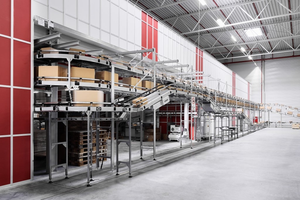 Conveyer belt with boxes on the move going into and out of the AutoStore facility