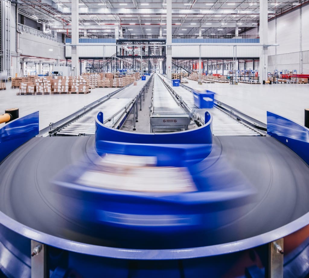 Conveyer belt with warehouse in background