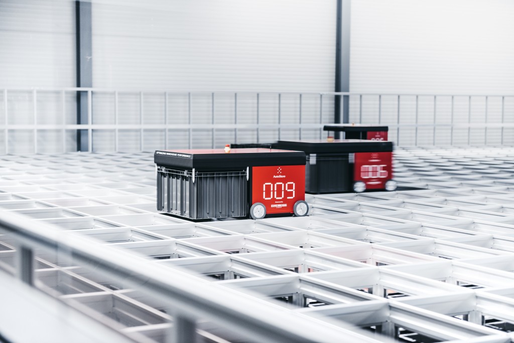 Three AutoStore robots driving on a grid system.