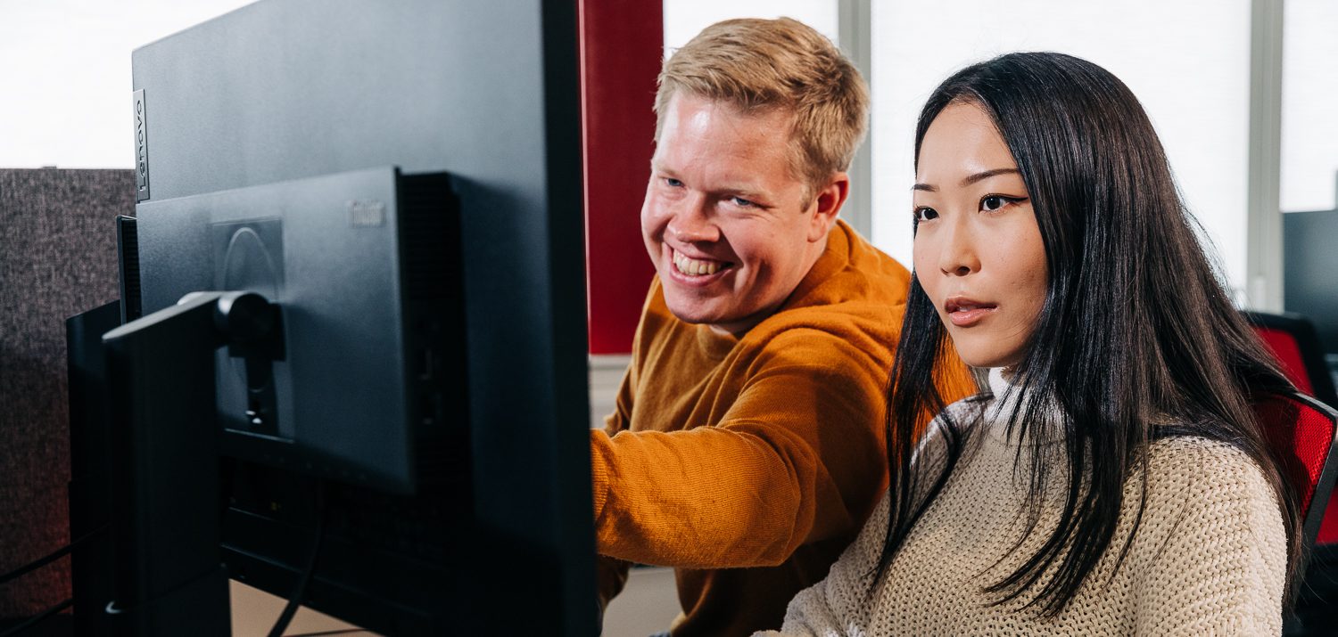 A man and a woman is looking at a computer screen