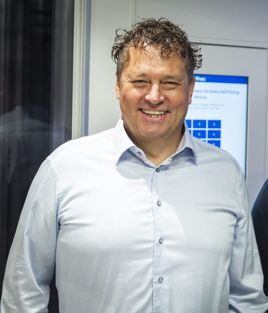 Man smiling beside an AutoStore port